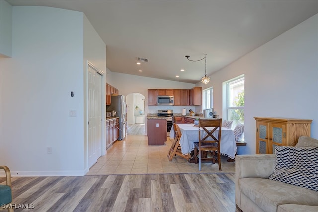 living room featuring arched walkways, light wood finished floors, lofted ceiling, recessed lighting, and visible vents