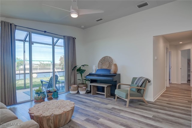 sitting room with light wood-style floors, visible vents, ceiling fan, and baseboards