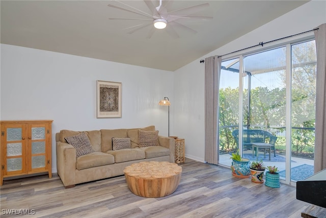 living area with a ceiling fan, baseboards, vaulted ceiling, and light wood finished floors