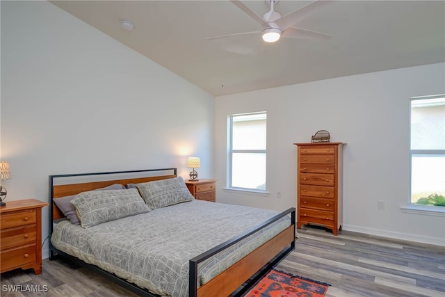 bedroom with light wood-type flooring, multiple windows, baseboards, and a ceiling fan