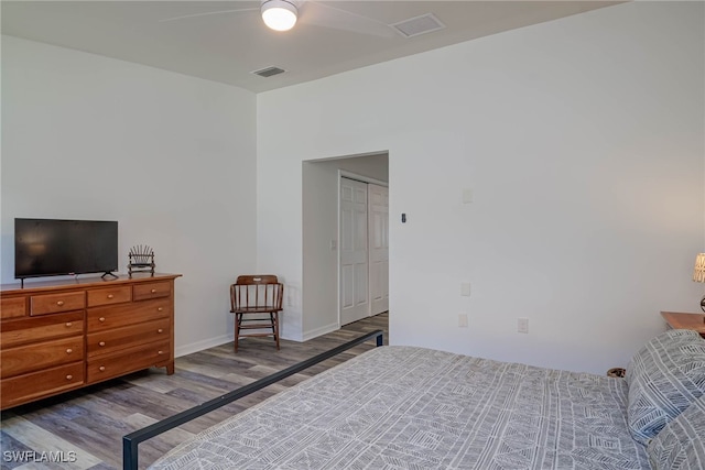 bedroom with a ceiling fan, baseboards, visible vents, and wood finished floors