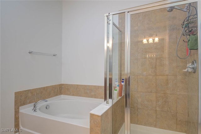 bathroom with a stall shower and a garden tub