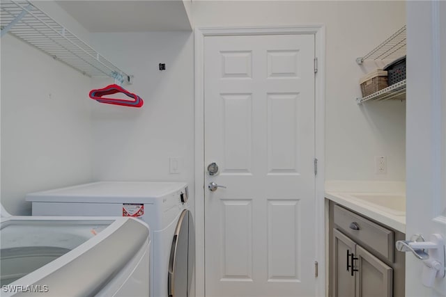 clothes washing area featuring cabinet space and washer and dryer