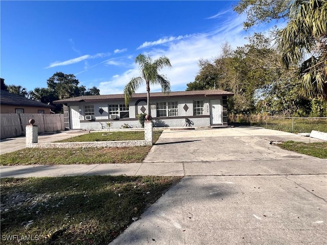 single story home featuring concrete driveway, a fenced front yard, and stucco siding