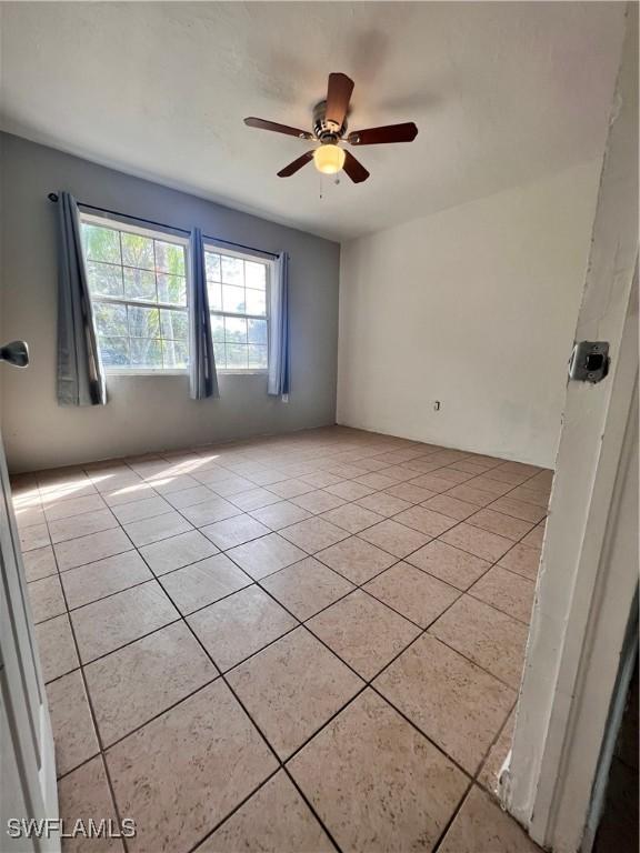 spare room featuring a ceiling fan and light tile patterned flooring