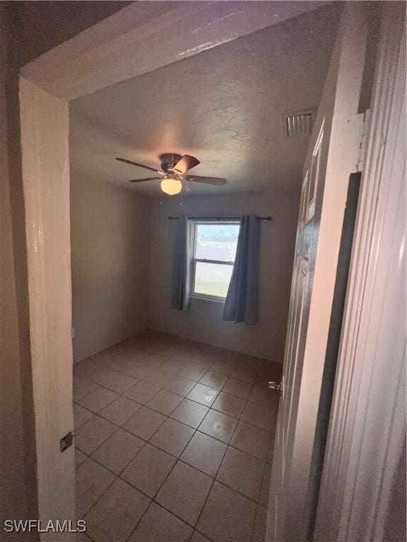 unfurnished room featuring light tile patterned floors, ceiling fan, and visible vents