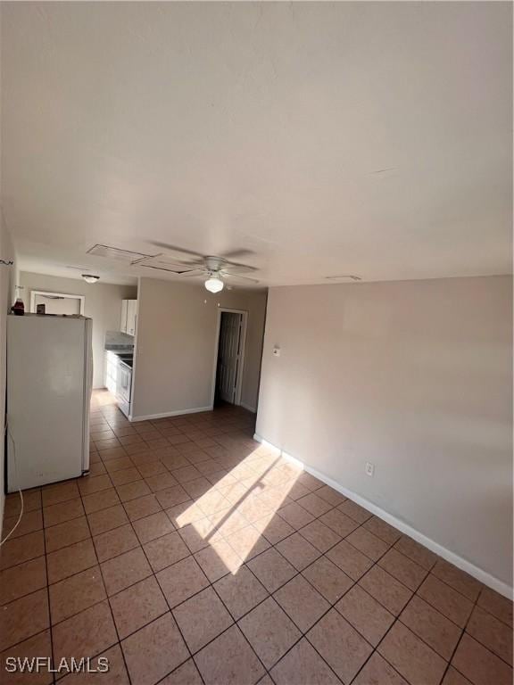 spare room with light tile patterned floors, baseboards, and a ceiling fan