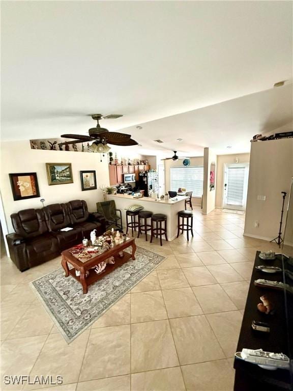 living room with light tile patterned floors, visible vents, and a ceiling fan