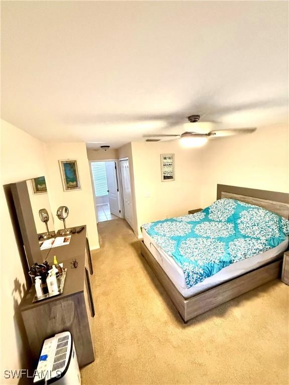 bedroom with ceiling fan and light colored carpet