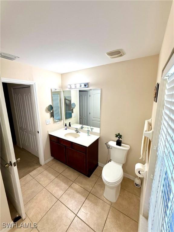 bathroom with double vanity, tile patterned flooring, visible vents, and toilet