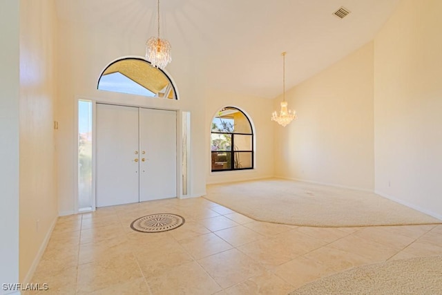 carpeted entryway with baseboards, visible vents, tile patterned floors, an inviting chandelier, and high vaulted ceiling