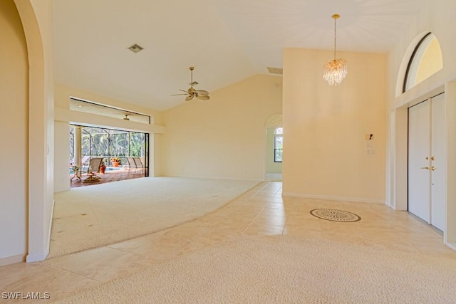 unfurnished living room featuring arched walkways, high vaulted ceiling, tile patterned flooring, ceiling fan with notable chandelier, and carpet flooring