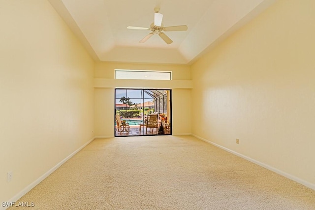 spare room featuring a ceiling fan, a tray ceiling, carpet flooring, and baseboards