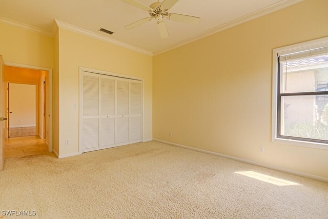 unfurnished bedroom with ornamental molding, a closet, carpet, and visible vents