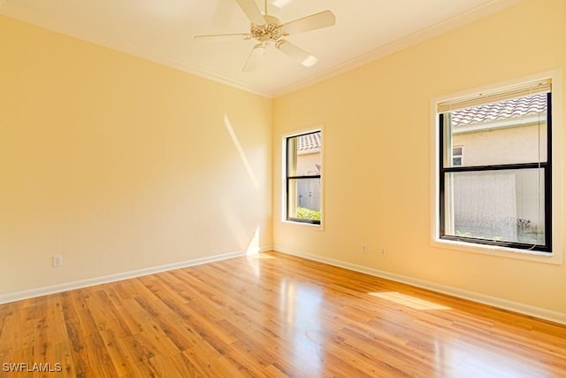 empty room featuring a ceiling fan, light wood-style flooring, ornamental molding, and baseboards