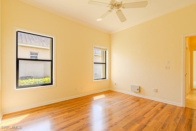 unfurnished room featuring ornamental molding, ceiling fan, baseboards, and wood finished floors