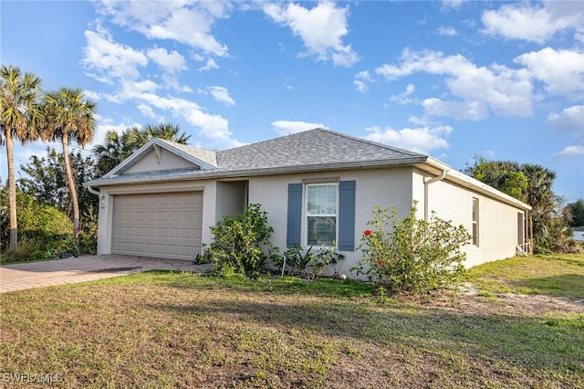 ranch-style house featuring an attached garage, a shingled roof, decorative driveway, stucco siding, and a front yard