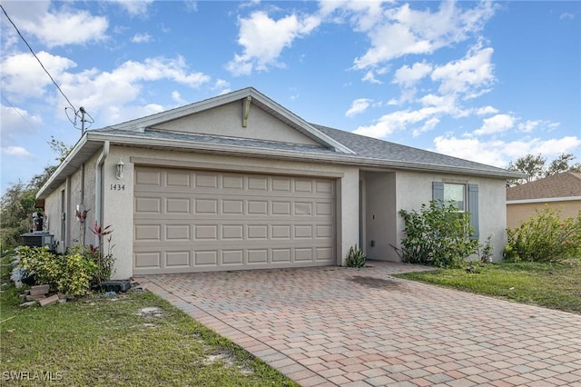 ranch-style house featuring a garage, decorative driveway, central AC, and stucco siding