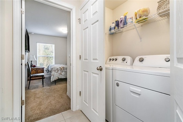 laundry room featuring light carpet, washing machine and dryer, and light tile patterned flooring