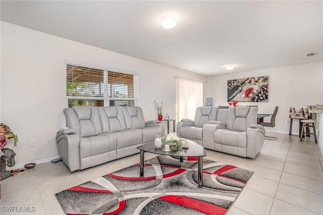 living room with light tile patterned floors, visible vents, and baseboards