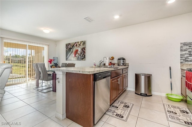 kitchen featuring light tile patterned flooring, a sink, visible vents, light countertops, and dishwasher