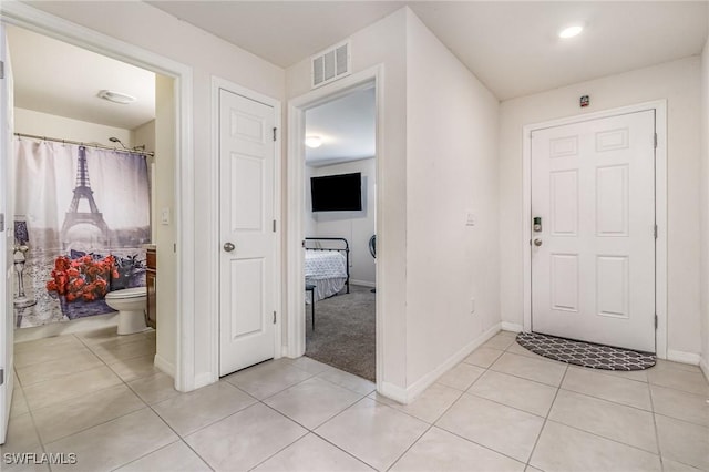 foyer with visible vents, baseboards, and light tile patterned floors