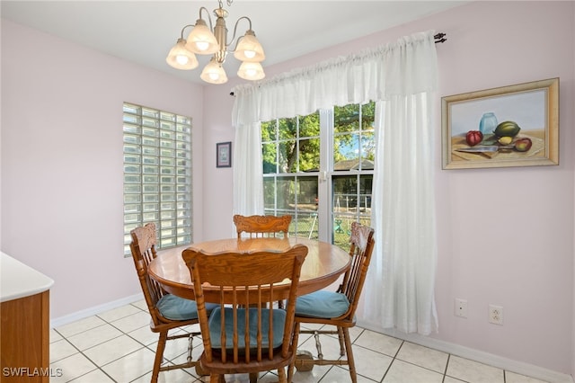 dining room with light tile patterned flooring, a notable chandelier, and baseboards