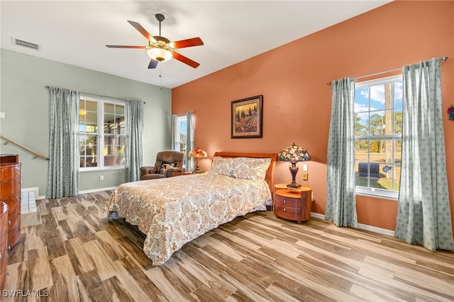 bedroom featuring visible vents, baseboards, wood finished floors, and a ceiling fan