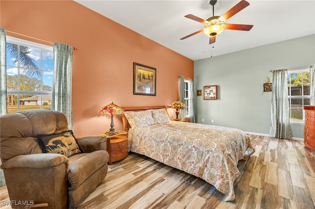 bedroom featuring light wood-style flooring, a ceiling fan, and baseboards