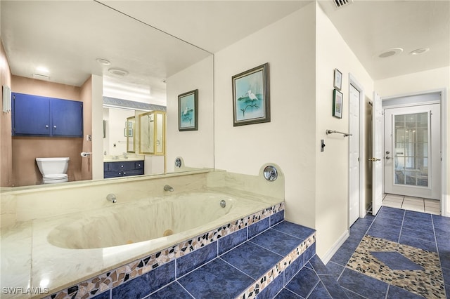 bathroom with a jetted tub, baseboards, toilet, tile patterned floors, and vanity