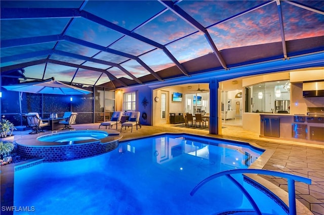 view of pool featuring a lanai, a patio area, an outdoor kitchen, and outdoor dining space