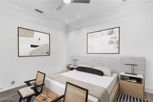 bedroom featuring baseboards, visible vents, dark wood finished floors, and ornamental molding