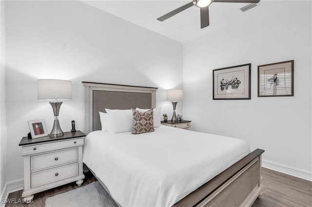 bedroom with visible vents, dark wood finished floors, a ceiling fan, and baseboards