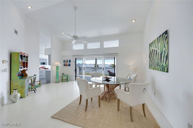 dining room featuring visible vents, baseboards, a towering ceiling, and recessed lighting