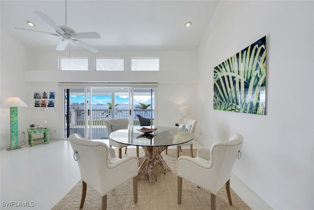 dining area with ceiling fan, a high ceiling, recessed lighting, and baseboards