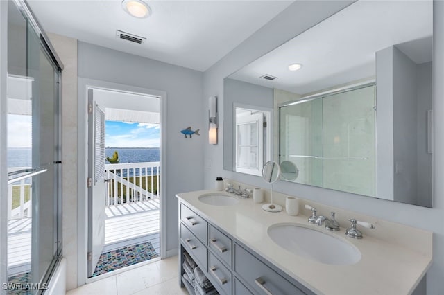 bathroom featuring a water view, a sink, visible vents, and double vanity