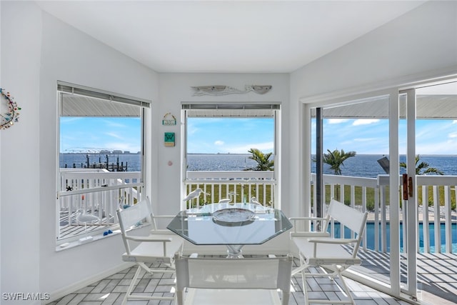 sunroom / solarium with a water view and plenty of natural light