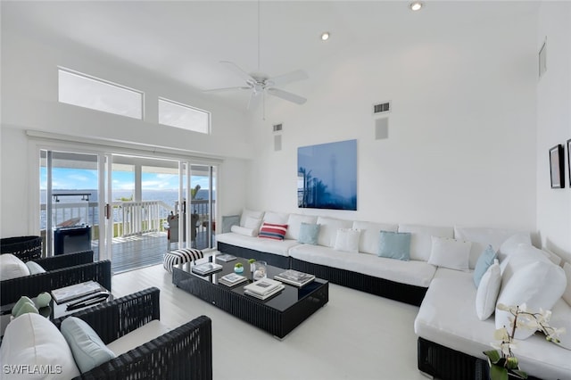 living room featuring a towering ceiling, visible vents, a ceiling fan, and recessed lighting