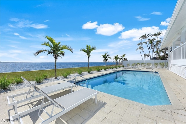 outdoor pool featuring a patio area and a water view