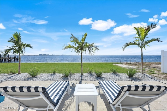 view of home's community with a patio area, a lawn, and a water view