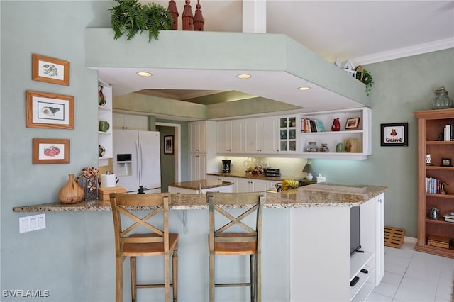 kitchen with white fridge with ice dispenser, white cabinets, glass insert cabinets, and open shelves