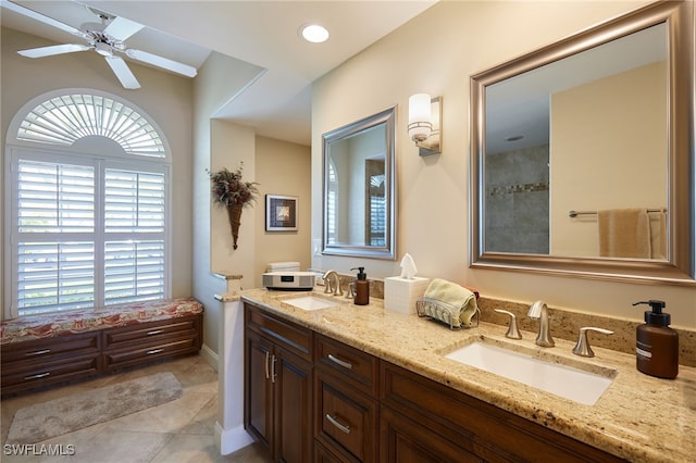 ensuite bathroom featuring double vanity, a sink, a ceiling fan, and tile patterned floors