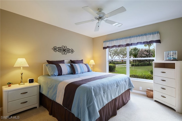 bedroom with a ceiling fan, light colored carpet, and baseboards