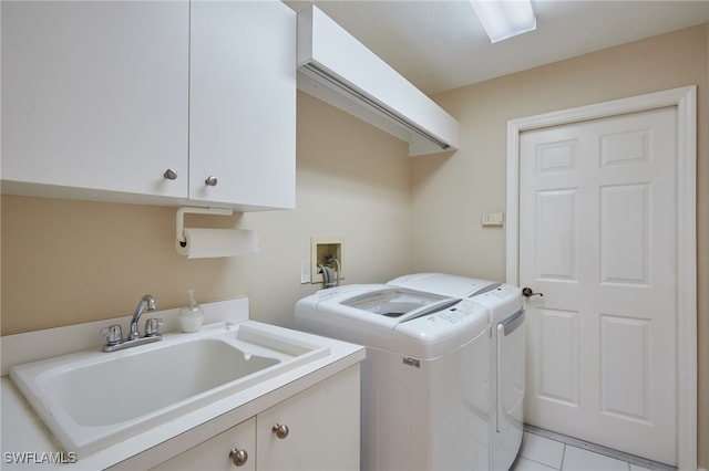 washroom featuring independent washer and dryer, a sink, and cabinet space