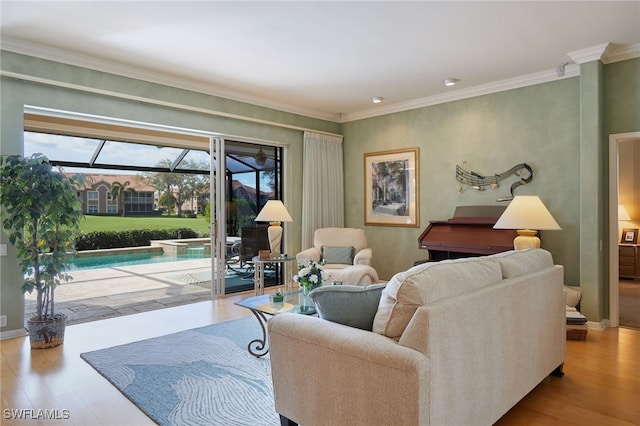 living area with a sunroom, baseboards, light wood finished floors, and crown molding