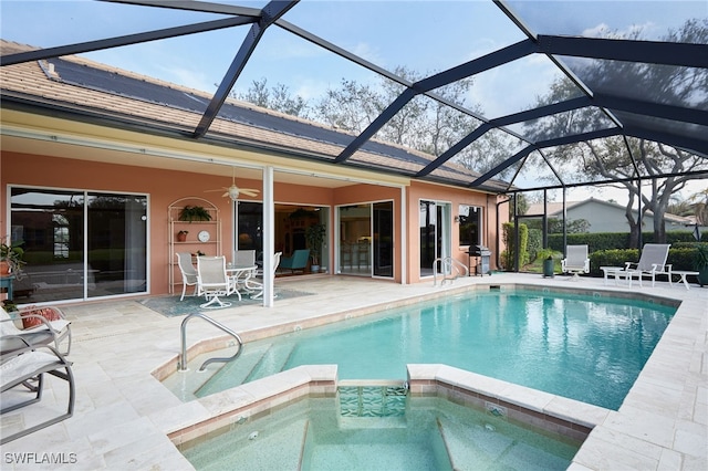 view of pool with a patio, a lanai, a pool with connected hot tub, a ceiling fan, and grilling area