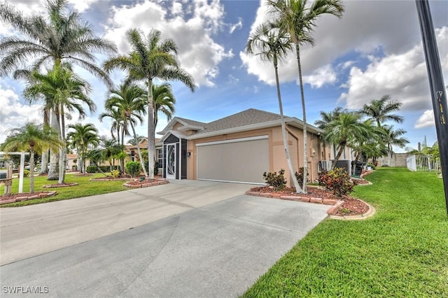 view of front of home featuring central AC unit, an attached garage, concrete driveway, stucco siding, and a front lawn