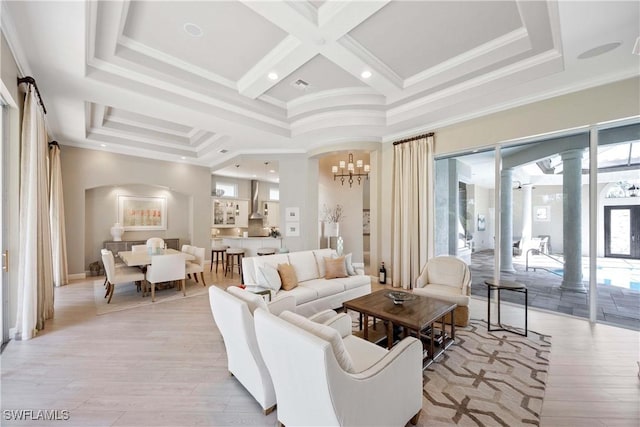 living room with a notable chandelier, coffered ceiling, light wood finished floors, beamed ceiling, and crown molding