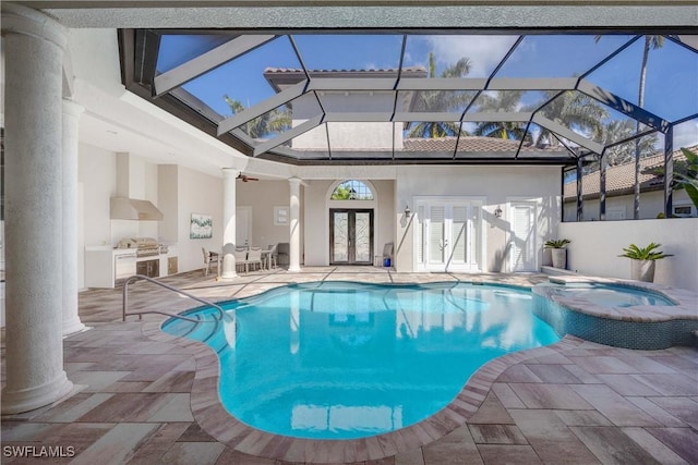 view of pool with french doors, a patio, a pool with connected hot tub, an outdoor kitchen, and a lanai