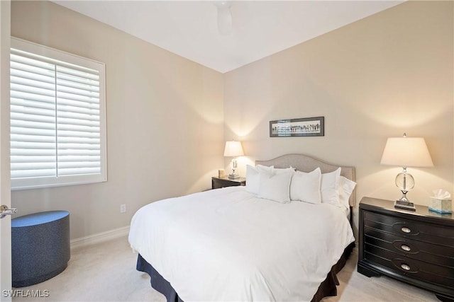 bedroom with baseboards, a ceiling fan, and light colored carpet